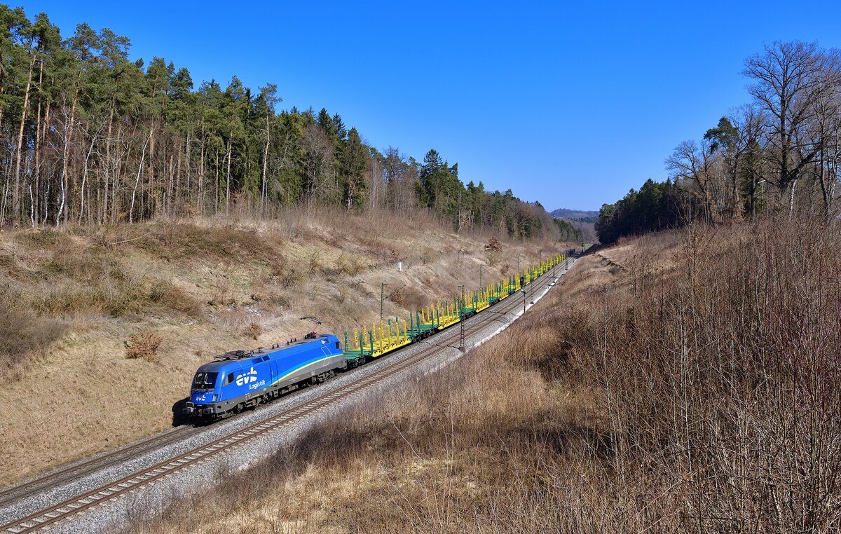 182 911 mit einem leeren Holzzug am 24.03.2022 bei Sinngrün.