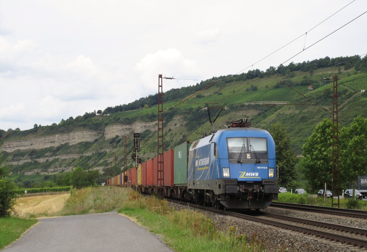 182 912 der Mittelweserbahn zieht am 11.August 2016 einen Containerzug bei Thngersheim in Richtung Wrzburg.