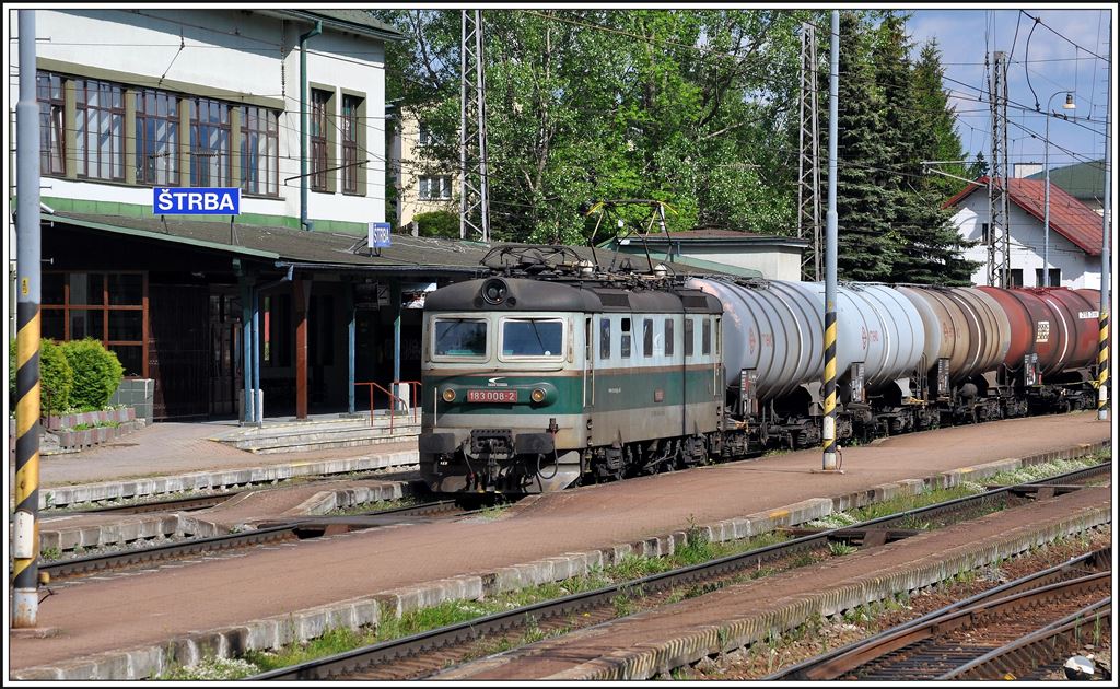 183 008-2 zieht einen langen Zisternenzug in den auf 895m ü/M. gelegenen Bahnhof Štrba, wo die Schublok abgehängt wird, um leer nach Poprad Tatry zurückzukehren. (05.06.2014)