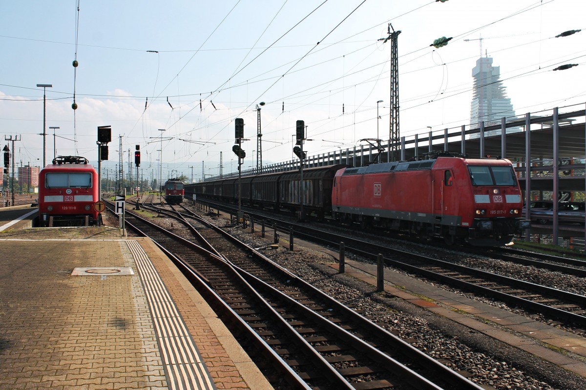 185 017-1 am 04.10.2014 bei der Durchfahrt mit einem Redbullzug (Bludenz - Bremerhaven/Hamburg) in Basel Bad Bf, den sie in Muttenz übernommen hat. Links im Bild steht 120 111-0 abgestellt am Bahnsteig und neben dran weiter im Hintergrund wartet Re 4/4 11111 auf die Ankunft des EC 9 (Hamburg Altona - Zürich HB) um diesen dann bis zum Endbahnhof zu befördern.