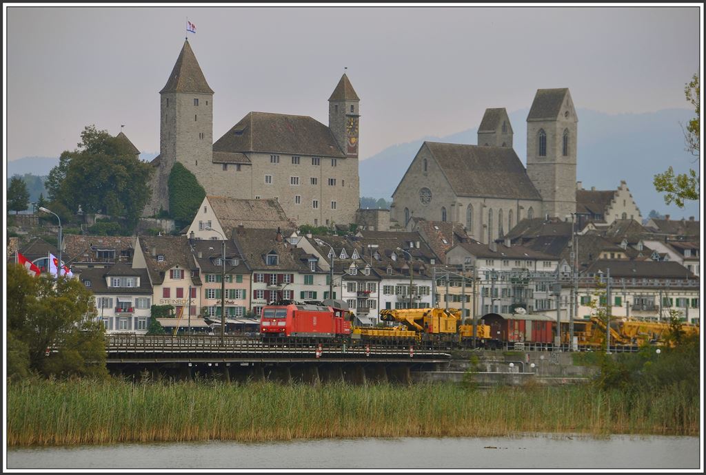 185 118-7 mit einem stattlichen Bauzug vor der Kulisse der Rosenstadt Rapperswil. (10.09.2015)