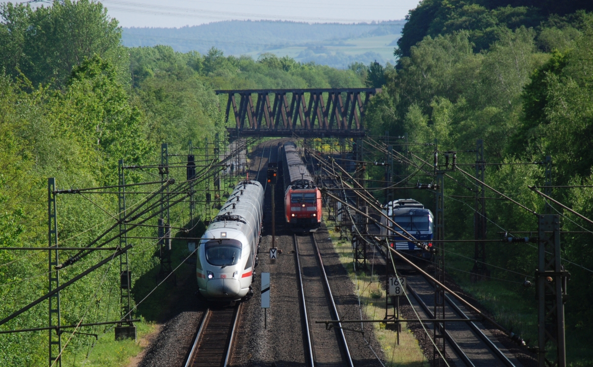 185 123 lässt in Blankenheim bei Bebra einem aus Erfurt kommenden ICE-T die Vorfahrt. Links ist noch ein als Lz fahrender Diesel-Vectron der Baureihe 247 zu sehen (8.5.2018)