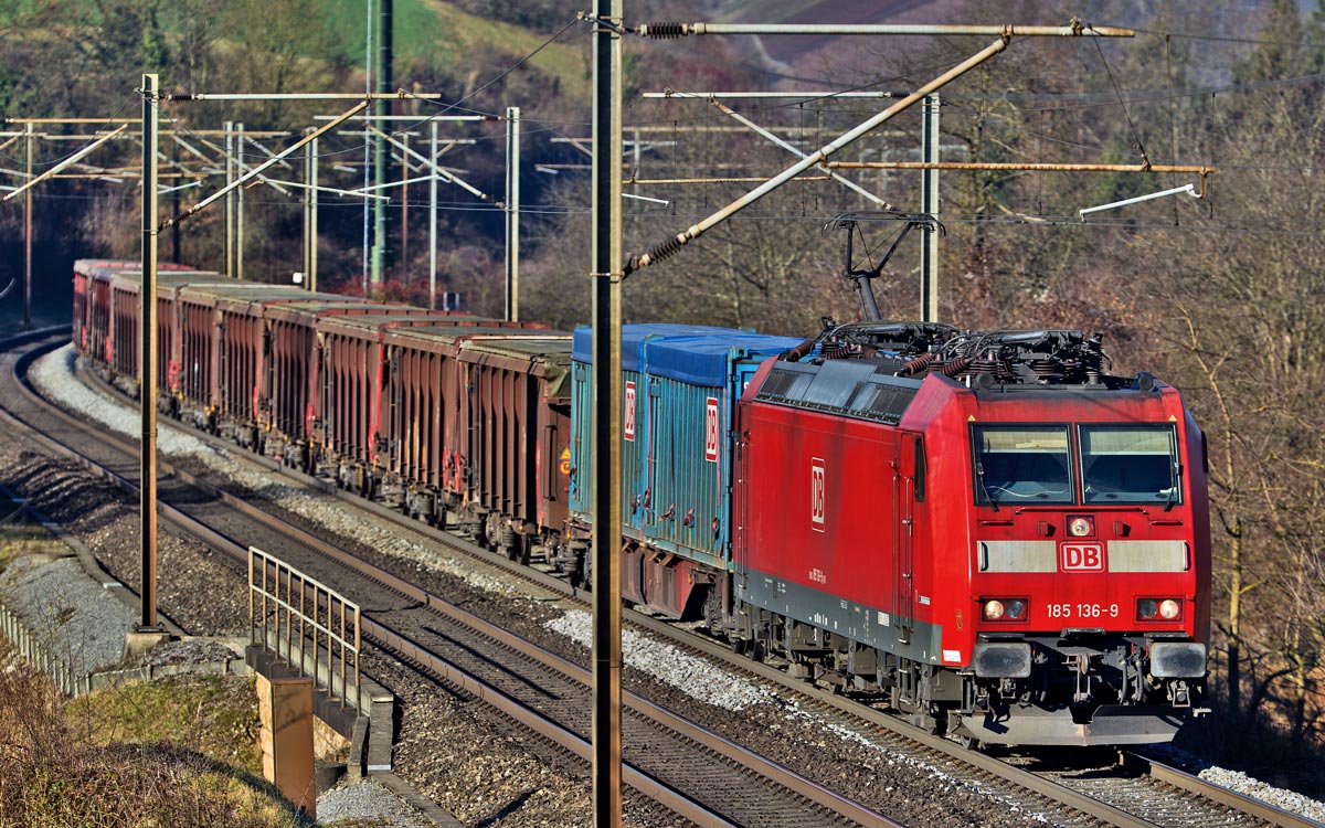 185 136-9 donnert in Hornussen mit einem Güterzug vorüber.Bild vom 6.12.2016