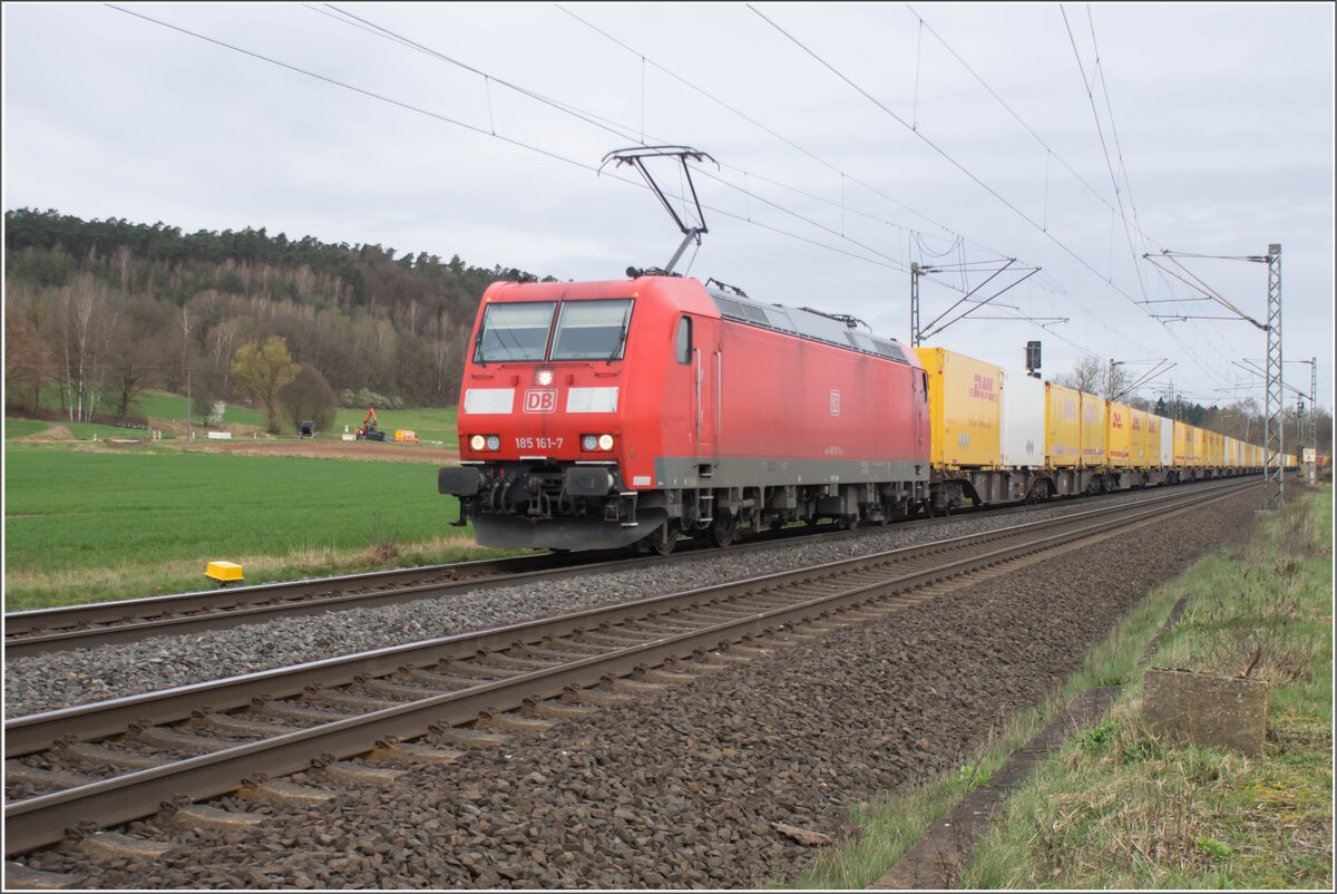 185 161-7 ist am 26.03.2024 mit einem DHL-Zug bei Kerzell in Richtung Süden unterwegs.