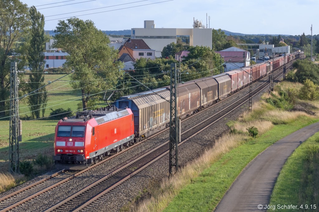185 182 mit einem Güterzug Richtung Würzburg am 4.9.15 nördlich von Ermetzhofen. Hinter dem Zug steht das große Gipswerk der Firma Knauf.
