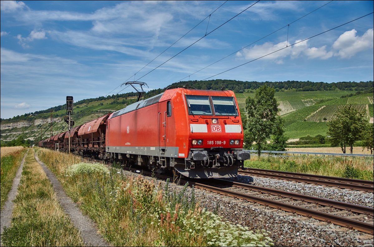 185 198-9 ist mit einen Schüttgutzug am 05.07.2017 bei Thüngersheim unterwegs.