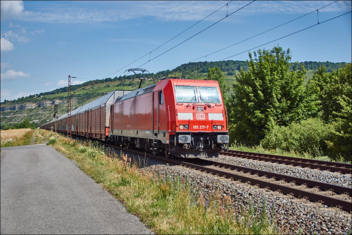 185 217-7 ist mit einen Altmann-Autozug bei Thüngersheim am 05.07.2017 unterwegs.