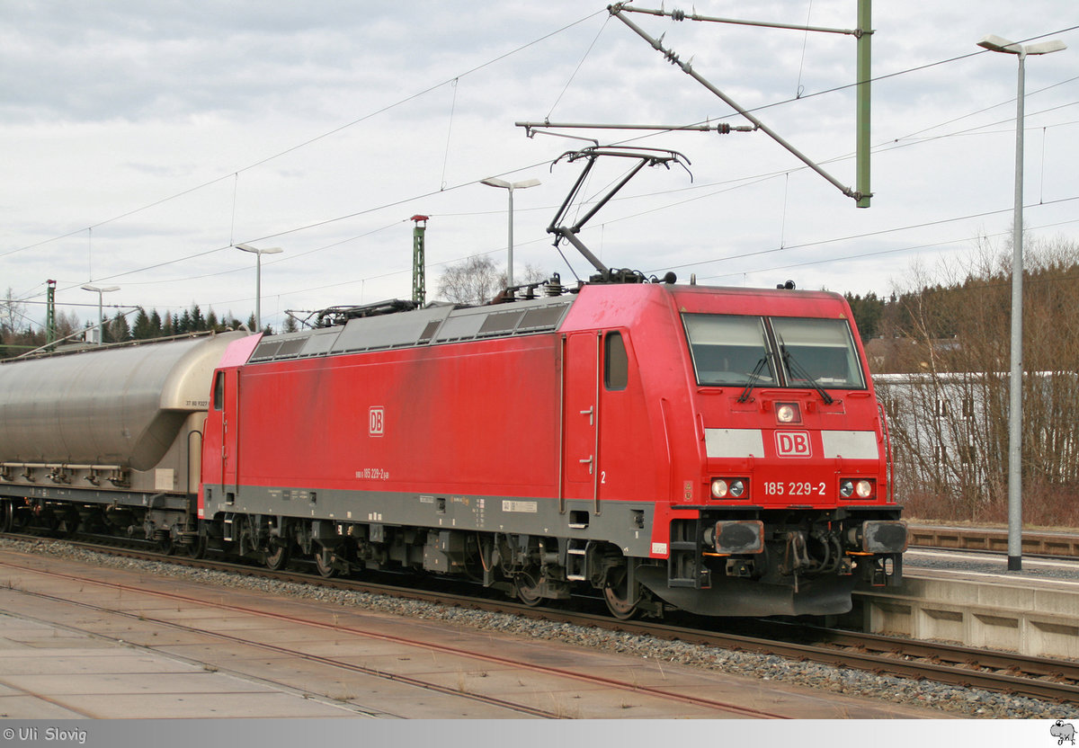 185 229-2 der Deutschen Bahn AG mit einen gemischten Güterzug am Haken hat gerade den Scheitelpunkt der Frankenwaldrampe, im Bahnhof Steinbach am Wald, erreicht. Die Aufnahme der südlich fahrenden Lok entstand am 11. März 2018.