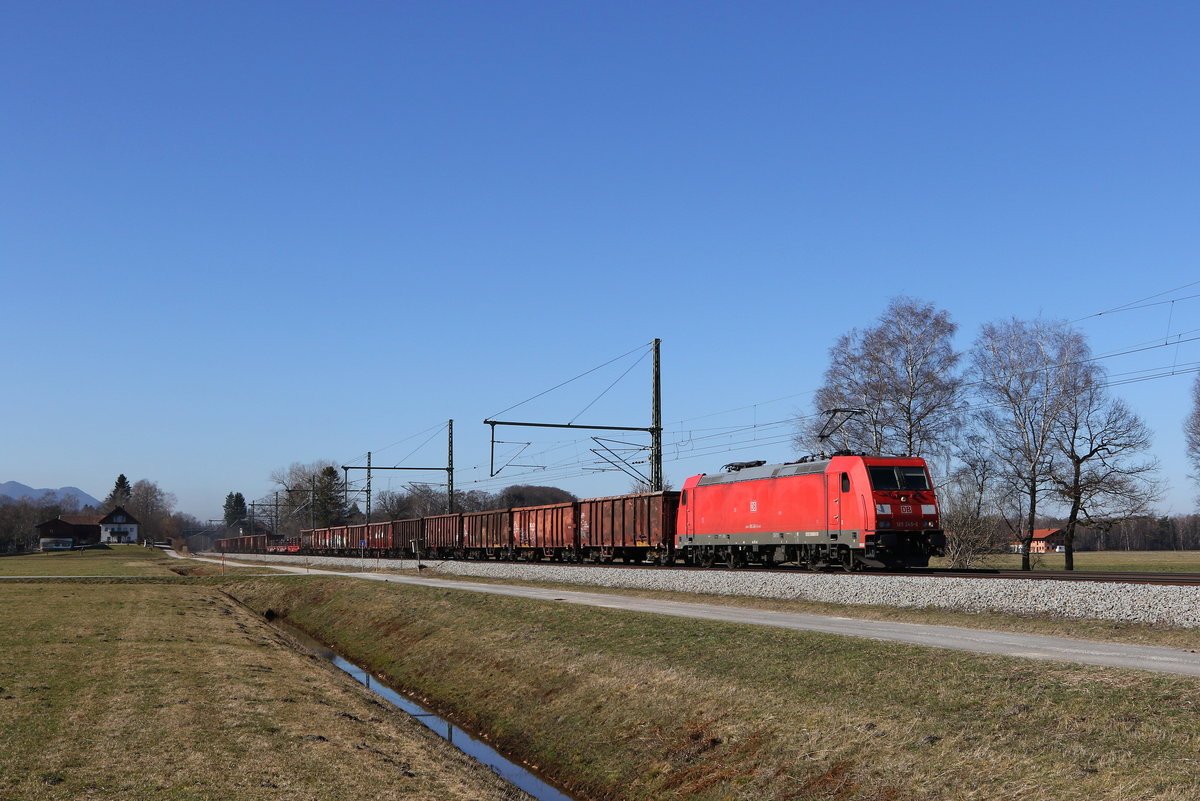 185 245 war am 1. März 2021 mit einem Stahlzug bei Übersee am Chiemsee in Richtung Freilassing unterwegs.