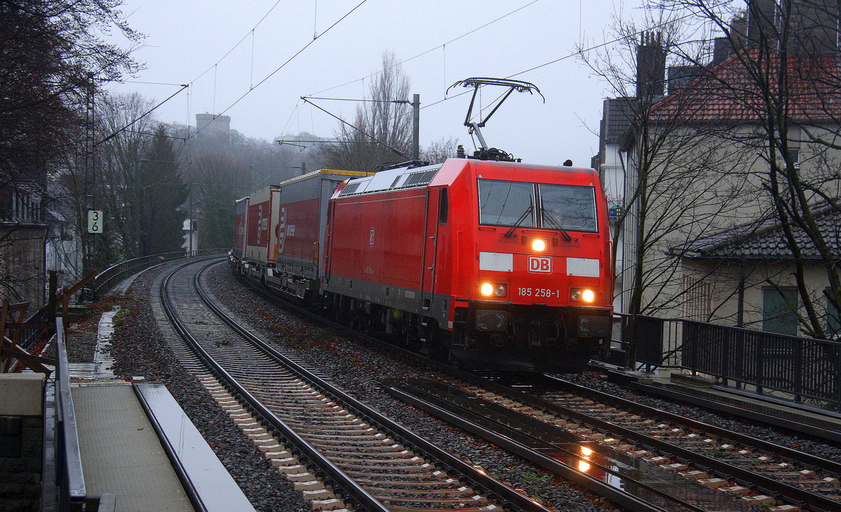 185 258-1 DB  kommt aus Richtung Aachen-West auf dem falschen Gleis mit einem Containerzug aus Zeebrugge(B) nach Gallarate(I) und fährt durch Aachen-Schanz in Richtung Aachen-Hbf,Aachen-Rothe-Erde,Stolberg-Hbf(Rheinland)Eschweiler-Hbf,Langerwehe,Düren,Merzenich,Buir,Horrem,Kerpen-Köln-Ehrenfeld,Köln-West,Köln-Süd. Aufgenommen vom Bahnsteig von Aachen-Schanz. 
Bei Regenwetter am Morgen vom 18.12.2017.