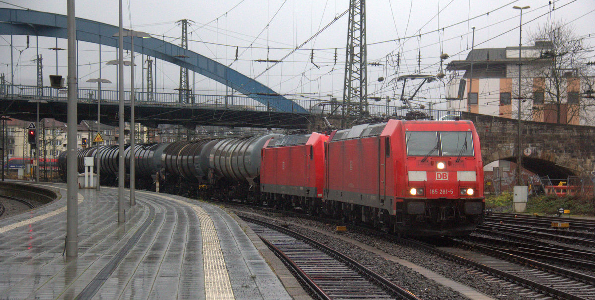 185 261-5 und 185 013-0 beide von DB kommen aus Richtung Aachen-West und fahren durch den Aachener-Hbf mit einem langen Ölzug aus Antwerpen-Petrol(B) nach Basel(CH) in Richtung Aachen-Rothe-Erde,Stolberg-Hbf(Rheinland)Eschweiler-Hbf,Langerwehe,Düren,Merzenich,Buir,Horrem,Kerpen-Köln-Ehrenfeld,Köln-West,Köln-Süd. Aufgenommen vom Bahnsteig 6 vom Aachen-Hbf. 
Bei Regenwetter am Nachmittag vom 22.12.2019.