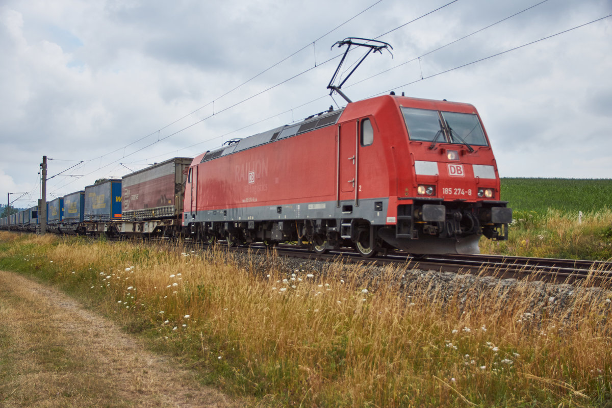 185 274-8 ist am 11.07.2018 mit einen Aufliegerzug bei Dörflein in Richtung Süden unterwegs.