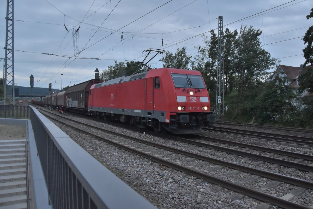 185 311-8 am Abend des 9. Juno 2020 in Neckarelz mit einem Mischer am Haken, der auch die Wagen mitführt, die am Mittag von der Holzverladung am Ort abgeholt und nach Heilbronn gebracht wurden. Ich gehe mal davon aus das der Zug nach Mannheim unterwegs ist.