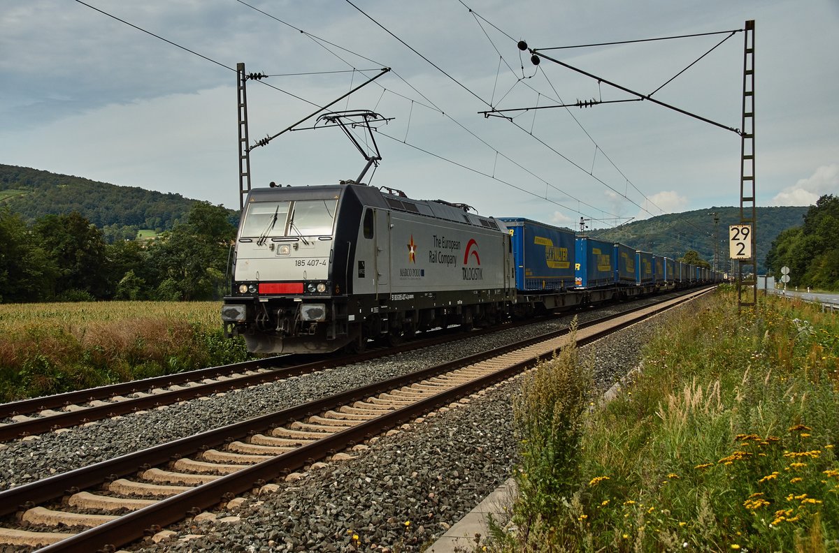 185 407-4 von TXLOGISTIK zieht einen Walterzug in Richtung Süden gesehen am 09.08.16 bei Gambach.