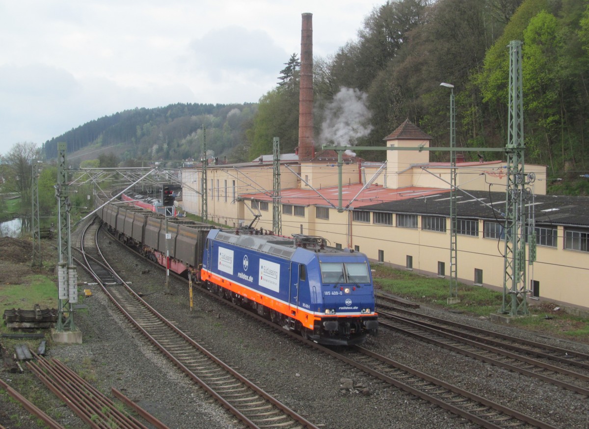 185 409-0 von Raildox zieht am 10. April 2014 einen leeren Sandzug durch Kronach in Richtung Saalfeld.