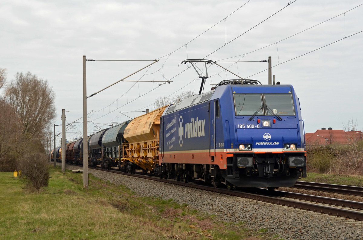 185 409 der raildox schleppte am 28.03.21 einen Schwenkdachwagenzug durch Greppin Richtung Bitterfeld.