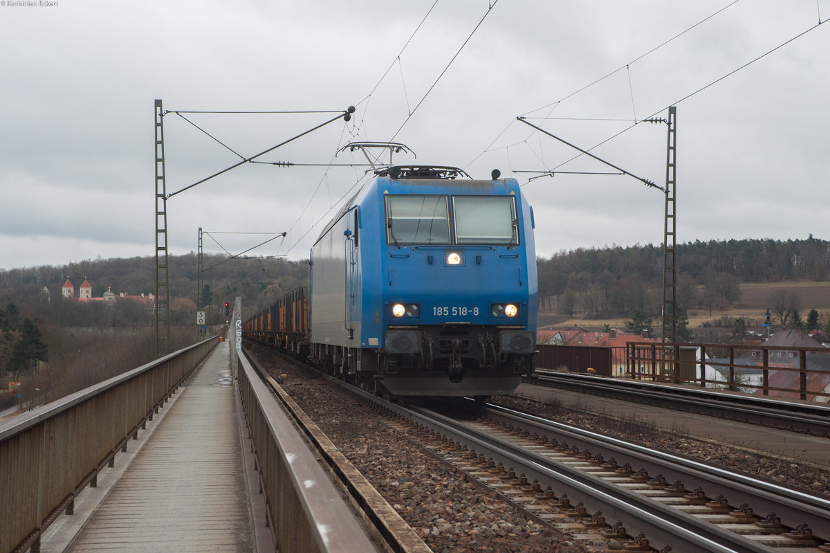 185 518 mit Flachwagen Richtung Nürnberg bei Überquerung der Mariaorter Eisenbahnbrücke in Regensburg-Prüfening, 28.02.2017