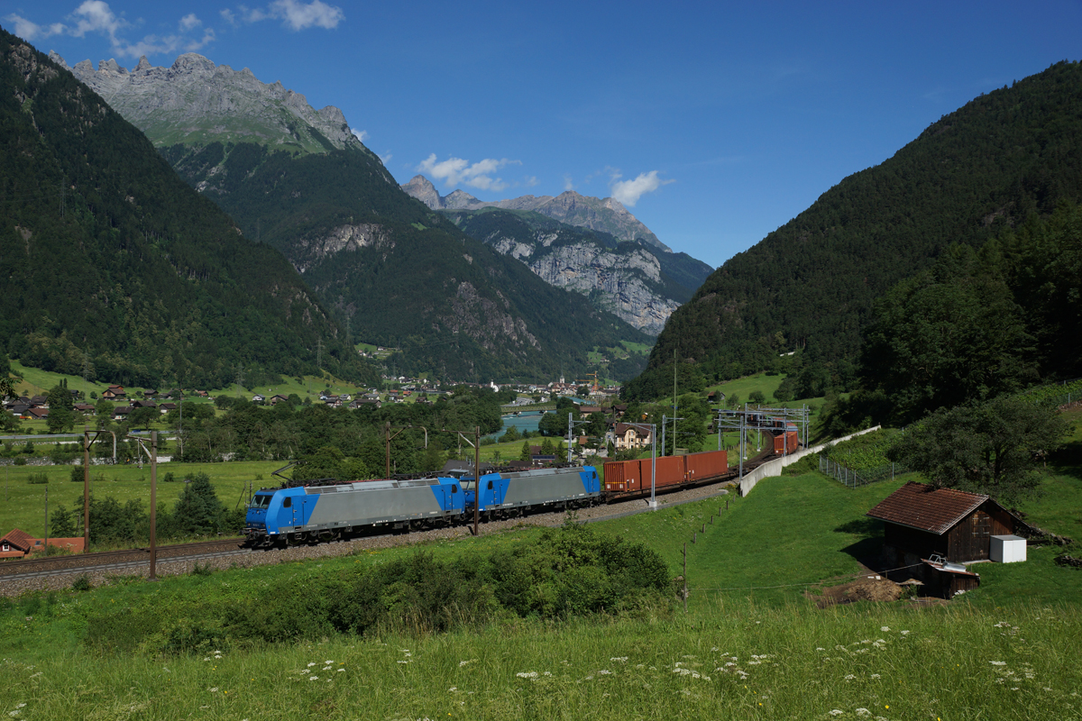 185 527-9 und 585 525-3 ziehen am 03.07.2014 einen Containerzug von Erstfeld Richtung Göschenen, aufgenommen kurz nach Erstfeld.
