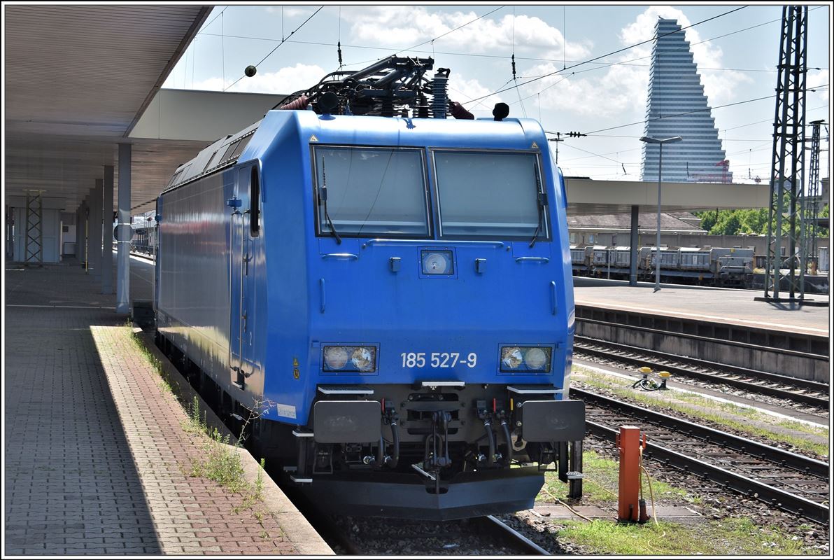 185 527-9 steht abgestellt in Basel Bad Bf. Im Hintergrund der Rocheturm, das derzeit höchste Gebäude der Schweiz. (16.07.2018)