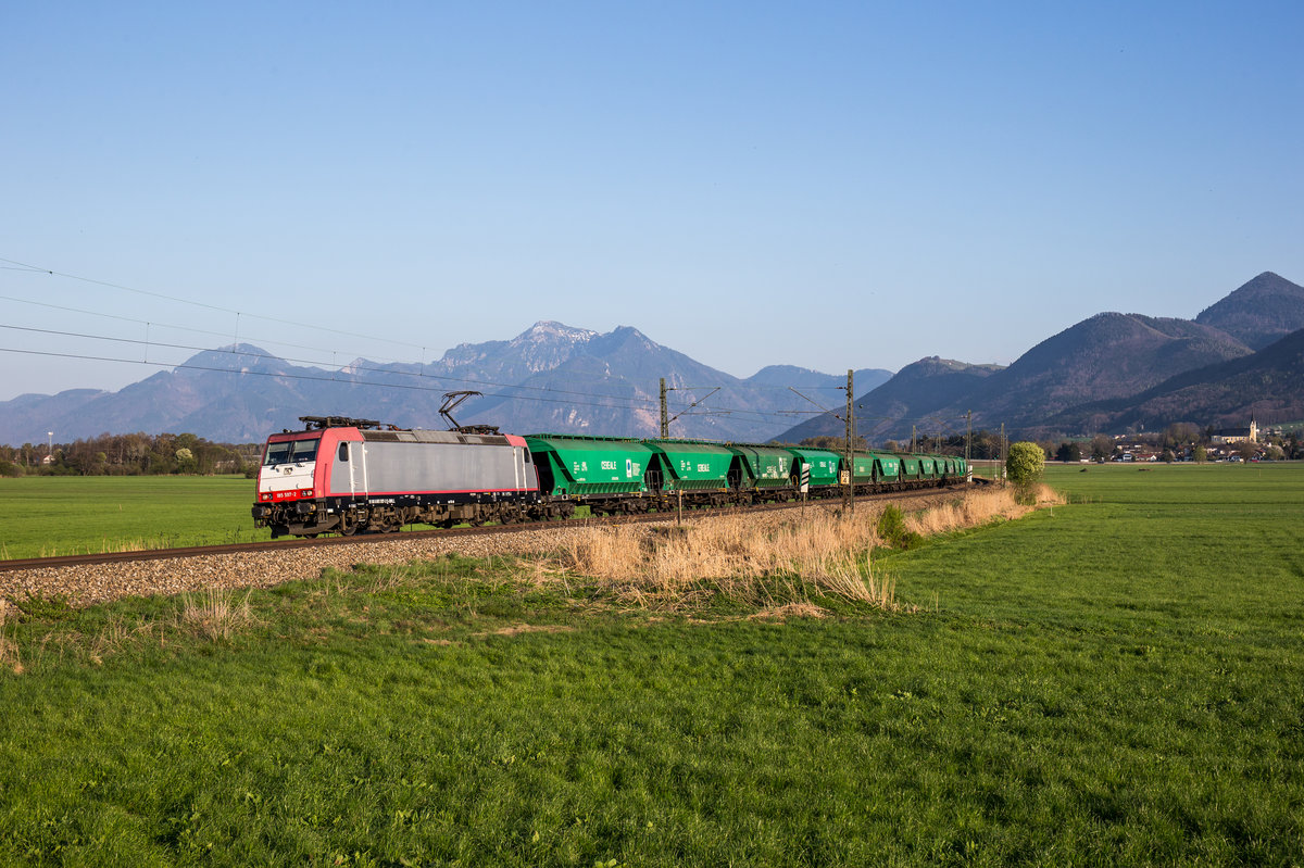 185 597 von HSL fährt mit einem Getreidezug bei Weisham in Richtung München, aufgenommen am 9. April 2017.
