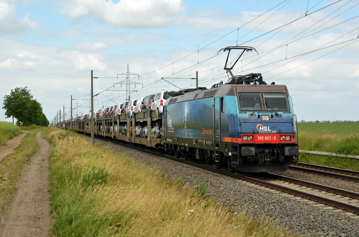 185 601 der HSL schleppte am 13.06.21 einen mit Toyotas beladenen BLG-Autozug durch Braschwitz Richtung Halle(S).