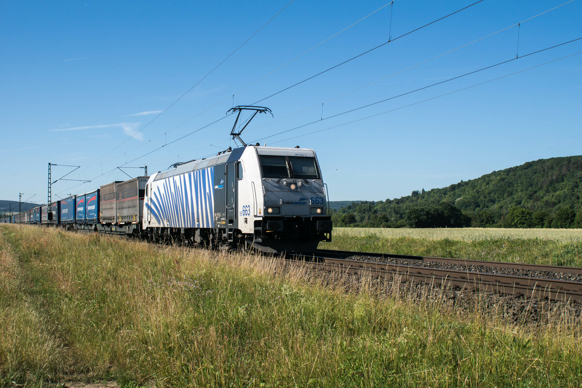 185 663-3 ist mit einem Aufliegerzug in Richtung Norden unterwegs,bei Himmelstadt am 15.06.2022