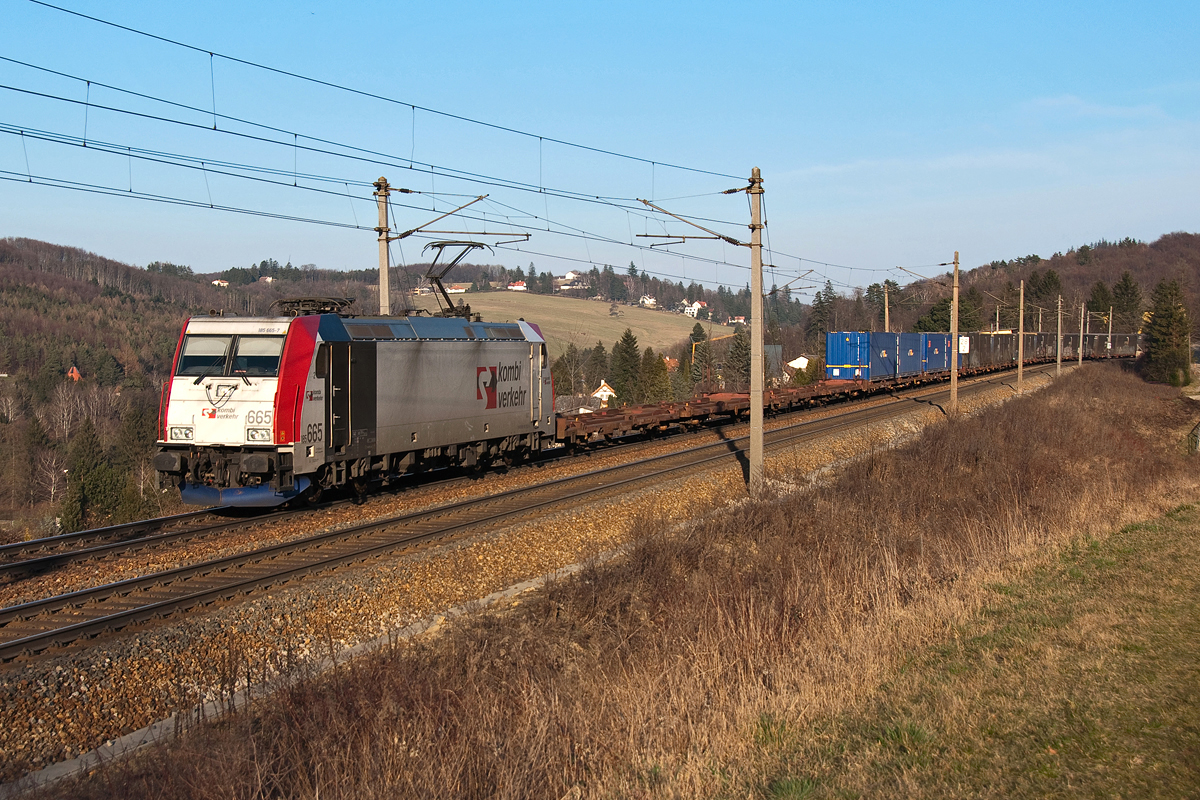 185 665  Kombiverkehr  ist mit einem Containerzug bei Eichgraben in Richtung St. Pölten unterwegs. Die Aufnahme entstand am 10.03.2014.