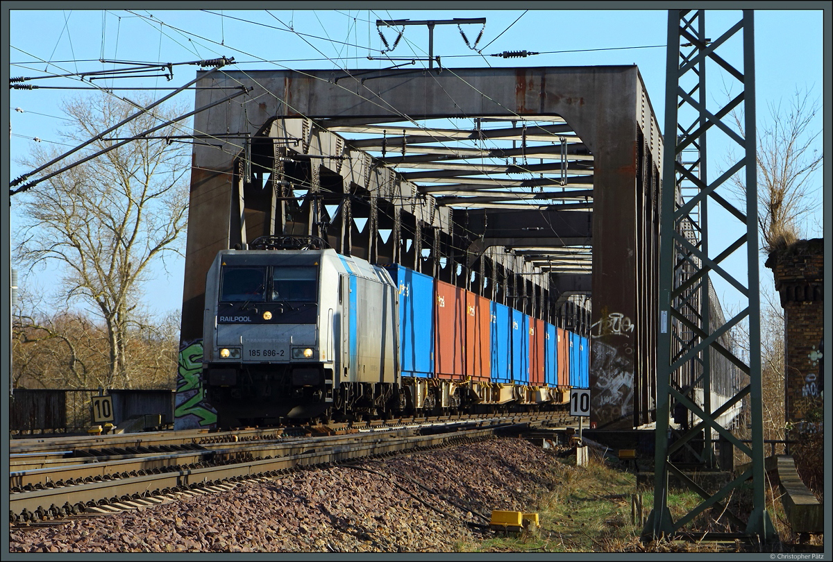 185 696-2 der TX Logistik zieht am 27.02.2022 einen Containerzug über die 1979 errichtete Elbbrücke in Magdeburg. 