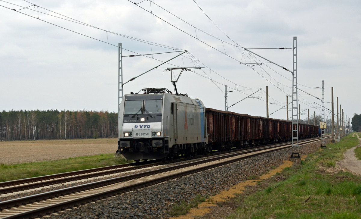 185 697 der Retrack/VTG führte am 12.04.19 einen Hochbordwagenzug durch Marxdorf Richtung Falkenberg(E).