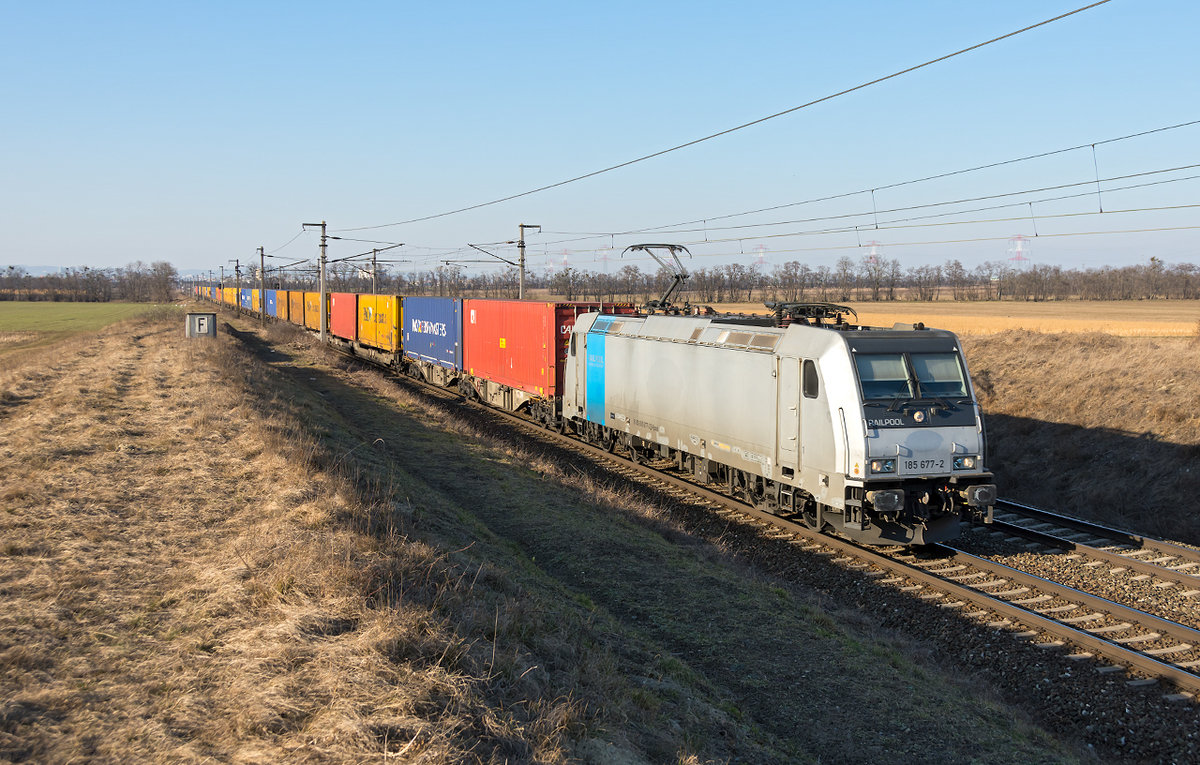 185 777 mit einem Containerzug, zwischen Himberg und Gramatneusiedl. Das Foto entstand am 15.02.2019.