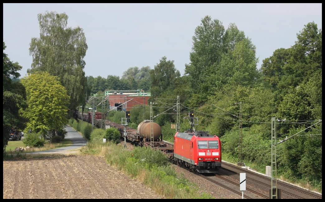 185010 fährt hier am 14.07.2018 mit einem gemischten Güterzug in Richtung Osnabrück um 10.55 Uhr durch den Stadtteil Osnabrück Hellern.