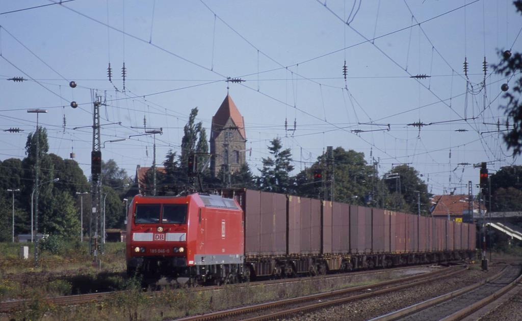 185046 fährt hier am 9.9.2004 um 16.32 Uhr vor der im Hintergrund sichtbaren evangelischen Kirche in Hohne mit einem Güterzug durch den Bahnhof Lengerich in Richtung Osnabrück.