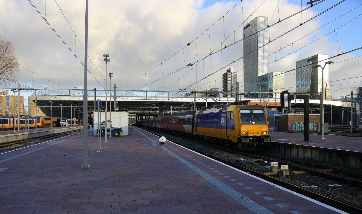 186 006 von NS fährt mit einem Schnellzug aus Breda(NL) nach Amsterdam-Ceentraal(NL)
bei der Ausfahrt von Rotterdam-Ceentraal(NL).
Aufgenommen in Rotterdam-Ceentraal(NL) bei Sonnenschein und Wolken am Nachmittag vom 4.1.2015.