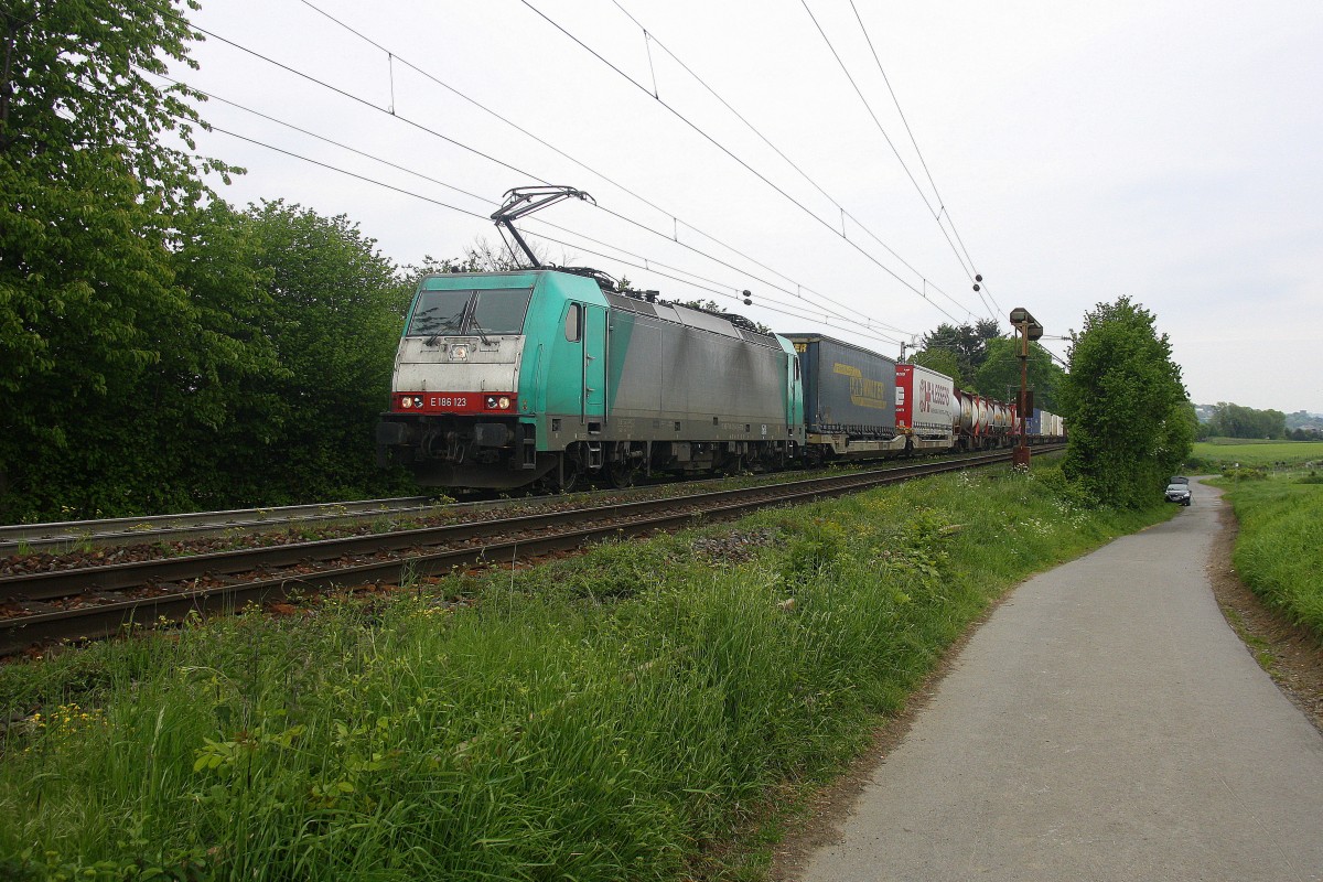 186 123 von Railtraxx kommt aus Richtung Aachen-West und fährt die Gemmenicher-Rampe hoch mit einem langen KLV-Containerzug aus Frankfurt-Höchstadt am Main(D) nach Genk-Goederen(B). 
Aufgenommen an der Montzenroute am Gemmenicher-Weg. 
Bei Regenwolken am 16.5.2015.