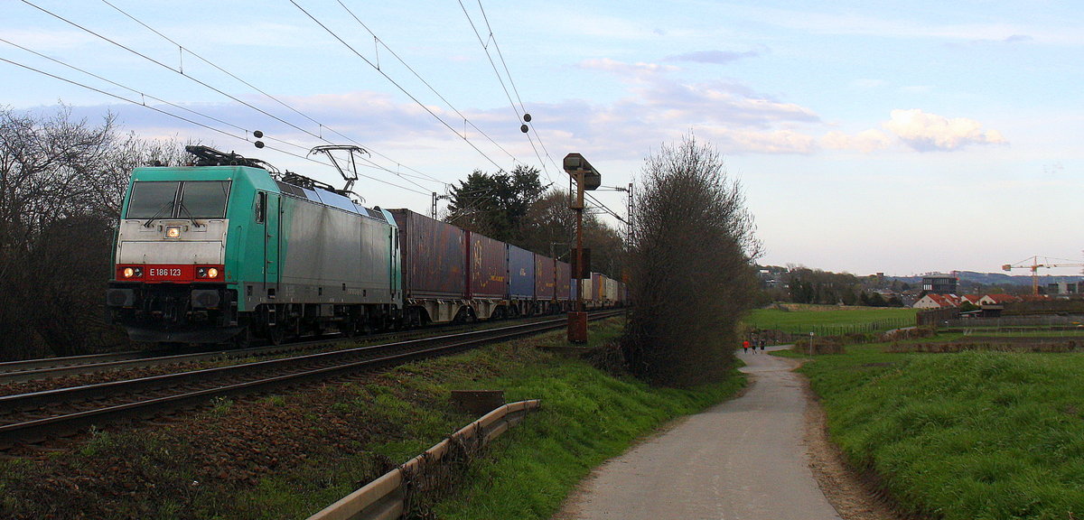 186 123 von Railtraxx kommt aus Richtung Aachen-West und fährt die Gemmenicher-Rampe hoch mit einem langen KLV-Containerzug aus Frankfurt-Höchstadt am Main(D) nach Genk-Goederen(B). 
Aufgenommen an der Montzenroute am Gemmenicher-Weg. 
Bei Sonne und Wolken am Abend vom 11.4.2016.
