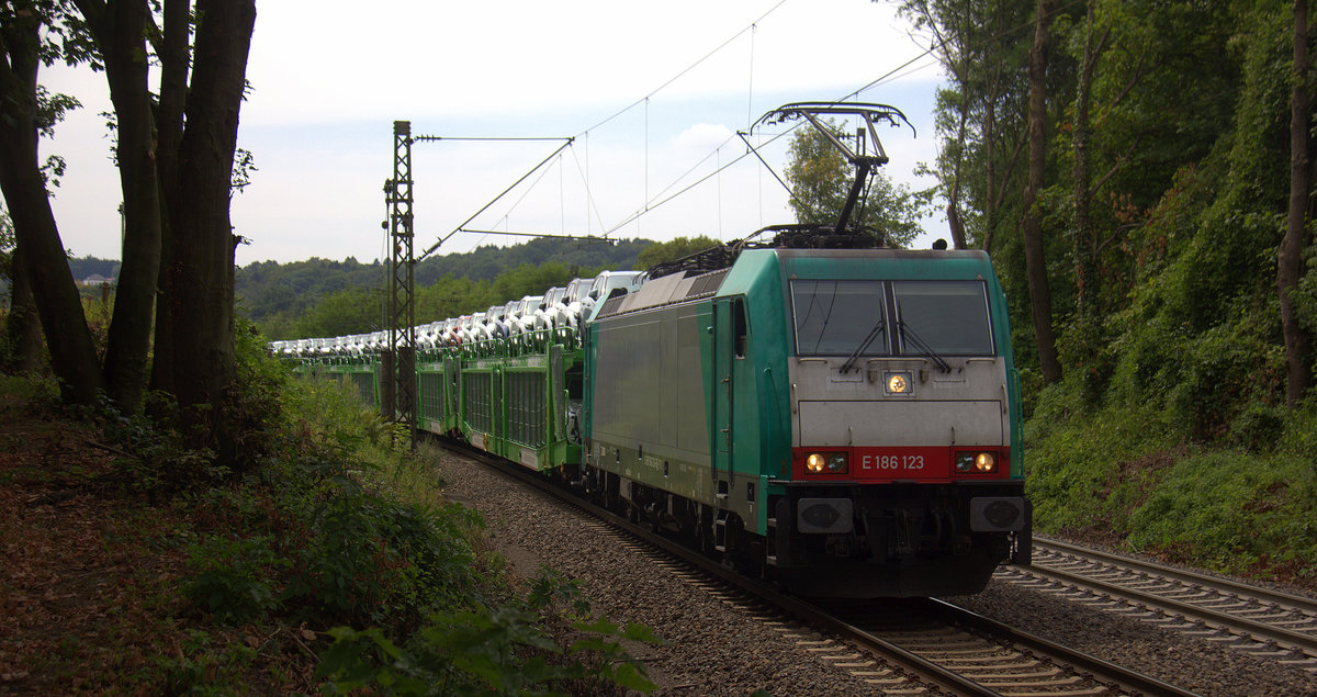 186 123 von Railtraxx kommt die Gemmenicher-Rampe herunter nach Aachen-West mit einem Volvo-Autozug aus Belgien nach Sankt-Valentin(A). 
Aufgenommen an der Montzenroute am Gemmenicher-Weg. 
Bei Wolken am Nachmittag vom 1.8.2018.