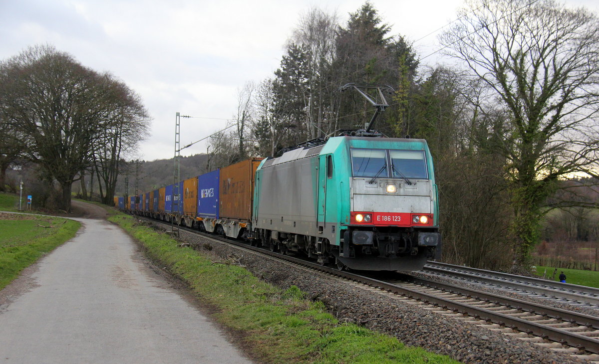 186 123 von Railtraxx  kommt die Gemmenicher-Rampe herunter nach Aachen-West mit einem Containerzug aus Zeebrugge-Ramskapelle(B) nach Milano-Segrate(I).
Aufgenommen an der Montzenroute am Gemmenicher-Weg. 
Bei Sonne und Regenwolken am Nachmittag vom 7.2.2019.