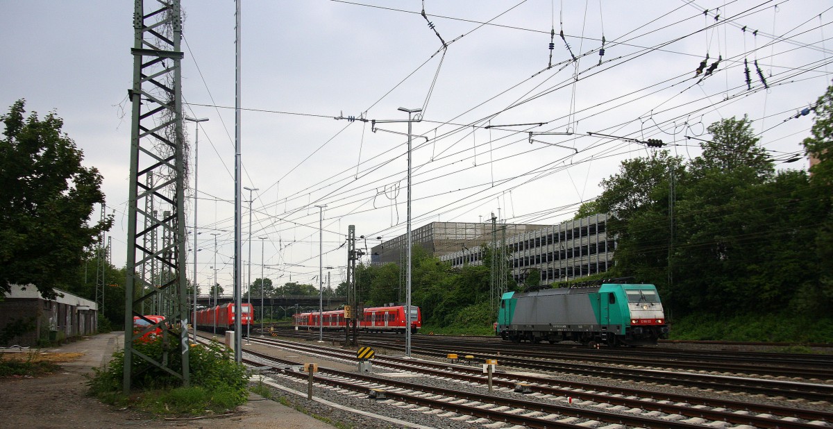 186 123 von Railtraxx rangiert in Aachen-West und im Hintergrund fährt die RB33 von Aachen-Hbf nach Heinsberg-Rheinland,Duisburg-Hbf bei Regenwetter am Nachmittag vom 19.6.2014.