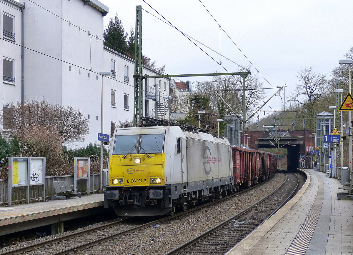 186 167-3 der Euro Cargo Rail kommt aus Richtung Köln,Aachen-Hbf und fährt durch Aachen-Schanz mit einem Schrottzug aus Köln-Kalk(D) nach Genk-Goederen(B) und fährt in Richtung Aachen-West. 
Aufgenommen vom Bahnsteig von Aachen-Schanz. 
Bei Schneewolken am Kalten Nachmittag vom 17.3.2018.