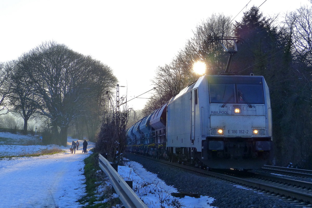 186 182-2 von Railpool kommt die Gemmenicher-Rampe herunter nach Aachen-West mit einem  Kalkzug aus Marche-les-Dames(B) nach Hagen(D).
Aufgenommen an der Montzenroute am Gemmenicher-Weg. 
In der Abendstimmung am Kalten Abend vom 8.2.2018.