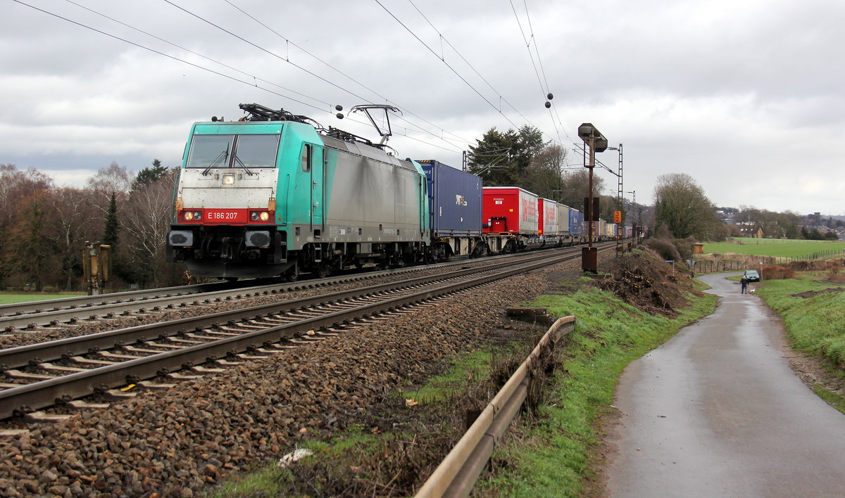 186 207 von der Rurtalbahn-Cargo kommt aus Richtung Aachen-West und fährt die Gemmenicher-Rampe hoch mit einem langen KLV-Containerzug aus Frankfurt-Höchstadt am Main(D) nach Genk-Goederen(B). Aufgenommen an der Montzenroute am Gemmenicher-Weg. 
Bei Sonne und Regenwolken am Vormittag vom 5.3.2019.