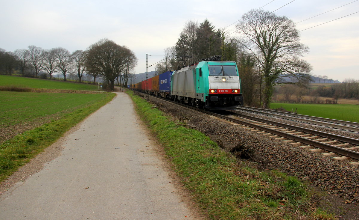186 216 von Railtraxx kommt die Gemmenicher-Rampe herunter nach Aachen-West mit einem Containerzug aus Zeebrugge-Ramskapelle(B) nach Milano-Segrate(I). Aufgenommen an der Montzenroute am Gemmenicher-Weg. 
Bei Sonne und Regenwolken am Nachmittag vom 21.2.2019.