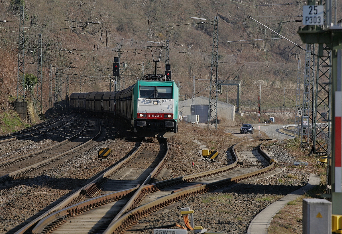 186 249 bei der Einfahrt in den Bahnhof Kaub am 10.03.2022 wechselt zunächst über alle drei Gleise, um nach wenigen hundert Metern ihre Fahrt im mittleren der drei Gleise fortzusetzen (warum so umständlich?).
