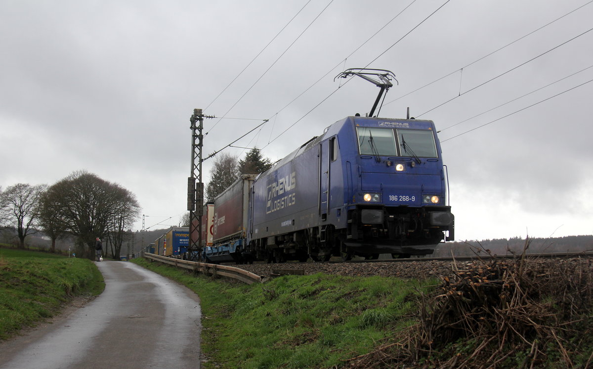 186 268-9 von Rhenus-Logistik kommt die Gemmenicher-Rampe herunter nach Aachen-West mit einem LKW-Zug aus Zeebrugge(B) nach Novara(I). 
Aufgenommen an der Montzenroute am Gemmenicher-Weg.
Bei Regenwetter am Mittag vom 5.3.2019. 