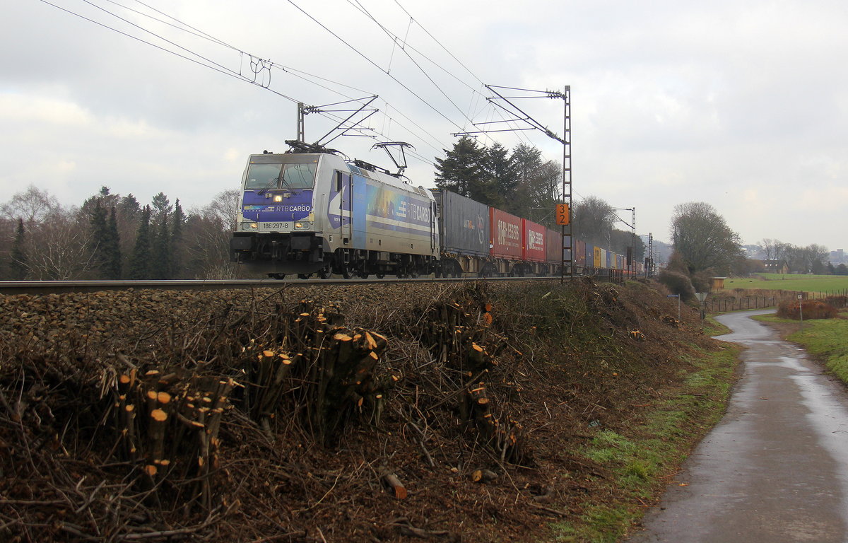186 297-8  Aachen  von der Rurtalbahn-Cargo kommt aus Richtung Aachen-West und fährt die Gemmenicher-Rampe hoch mit einem langen KLV-Containerzug aus Frankfurt-Höchstadt am Main(D) nach Genk-Goederen(B).
Aufgenommen an der Montzenroute am Gemmenicher-Weg. 
Bei Sonne und Regenwolken am Nachmittag vom 22.2.2019.