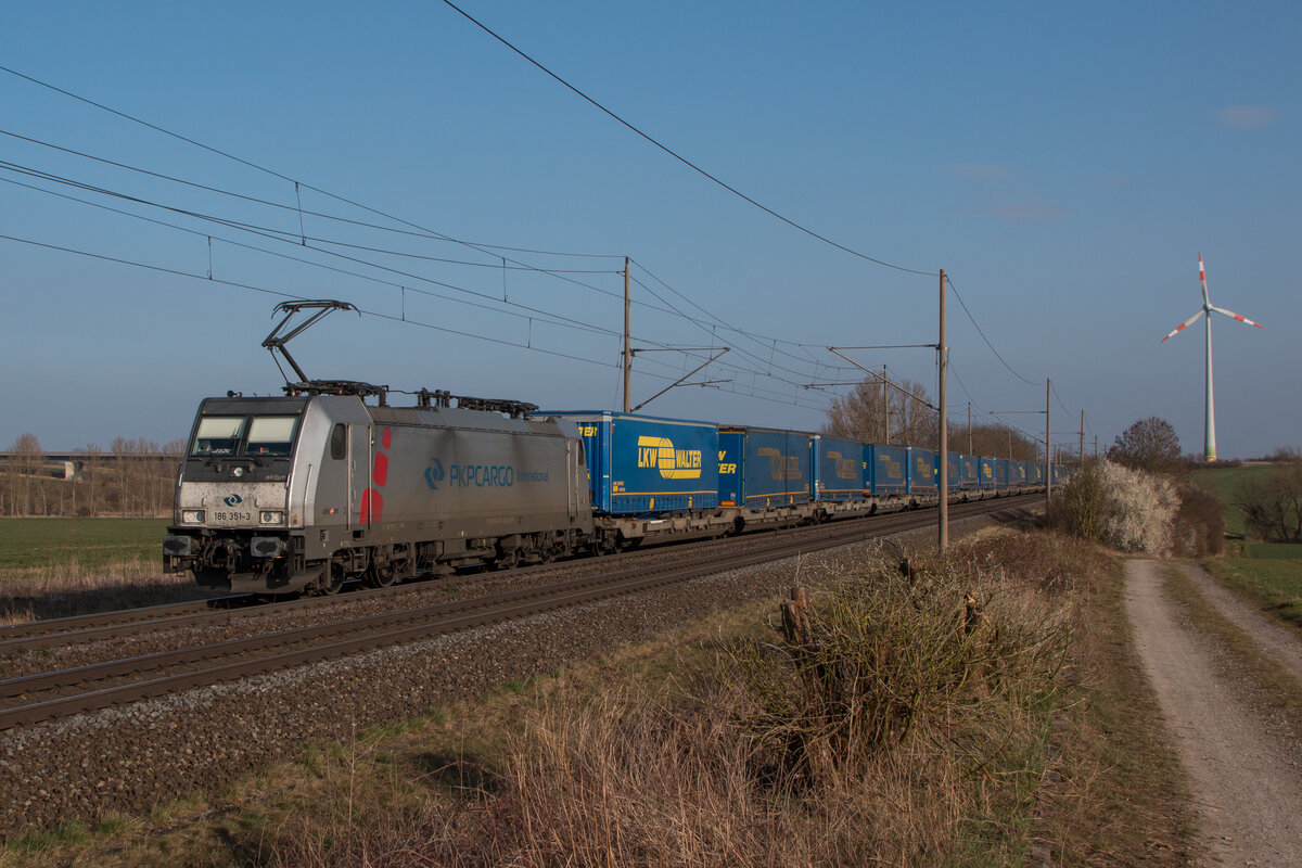 186 351-3 von PKP Cargo International ist mit einem LKW Walter KLV-Zug in Richtung Braunschweig unterwegs. Fotografiert am 28.03.2022 in Niederndodeleben.