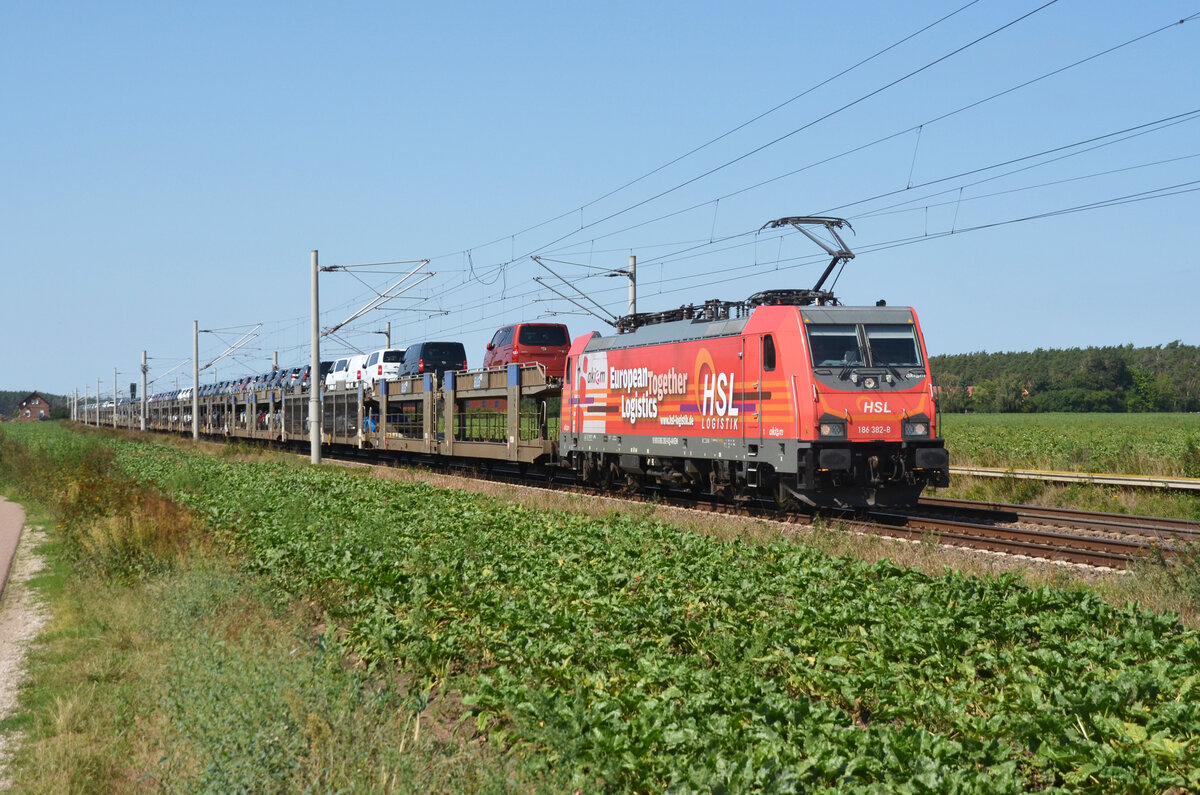 186 382 der HSL schleppte am 28.08.22 ihren Toyota-Zug durch Rodleben Richtung Roßlau.