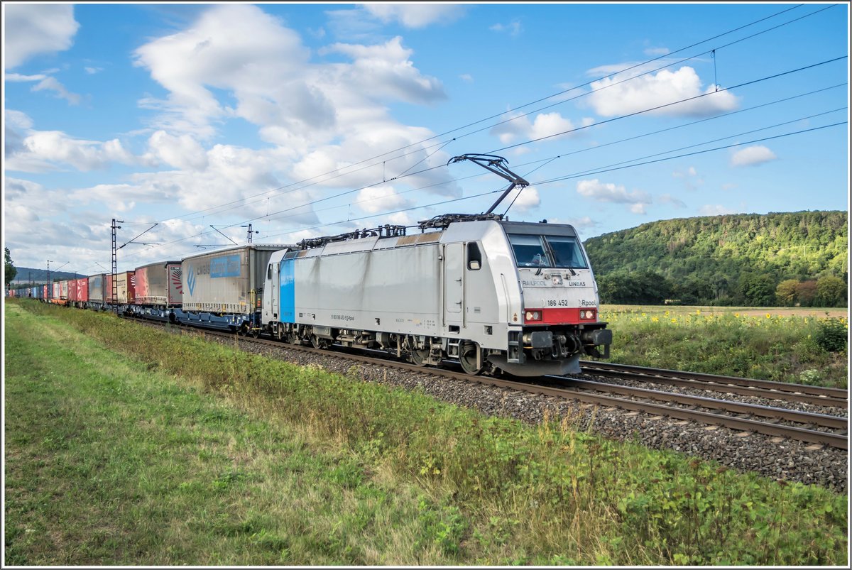 186 452-9 ist am 26.08.2020 mit einen Aufliegerzug bei Himmelstadt unterwegs.