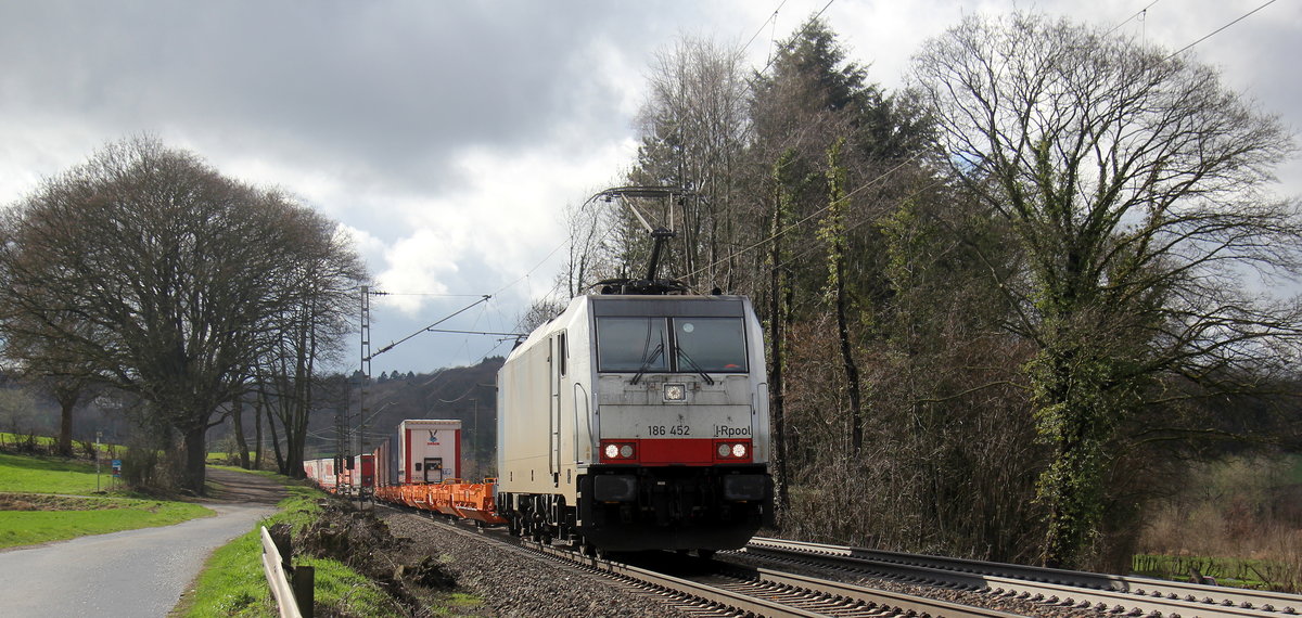186 452-9 von Lineas/Railpool kommt die Gemmenicher-Rampe herunter nach Aachen-West mit einem Containerzug aus Belgien nach Aachen-West(D) und fährt in Richtung Aachen-West. 
Aufgenommen an der Montzenroute am Gemmenicher-Weg. 
Bei Sonne und Regenwolken am Mittag vom 5.3.2019.