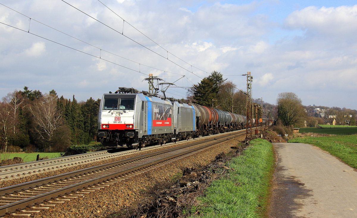 186 493-3 und 186 499-0 beide von DB-Schenker kommen die Gemmenicher-Rampe hochgefahren aus Richtung Aachen-West mit einem langen Ölleerzug aus Basel(CH) nach Antwerpen-Petrol(B) und fahren in Richtung Gemmenicher-Tunnel,Botzelaer(B),Gemmenich(B),Nouvelaer(B),Moresnet(B),Moresnet-Chapelle(B),Montzen(B). Aufgenommen an der Montzenroute am Gemmenicher-Weg. 
Bei Sonne und Regenwolken am Mittag vom 8.3.2019.